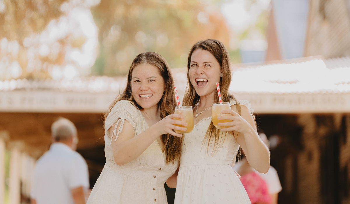 Two people smiling and drinking cocktails